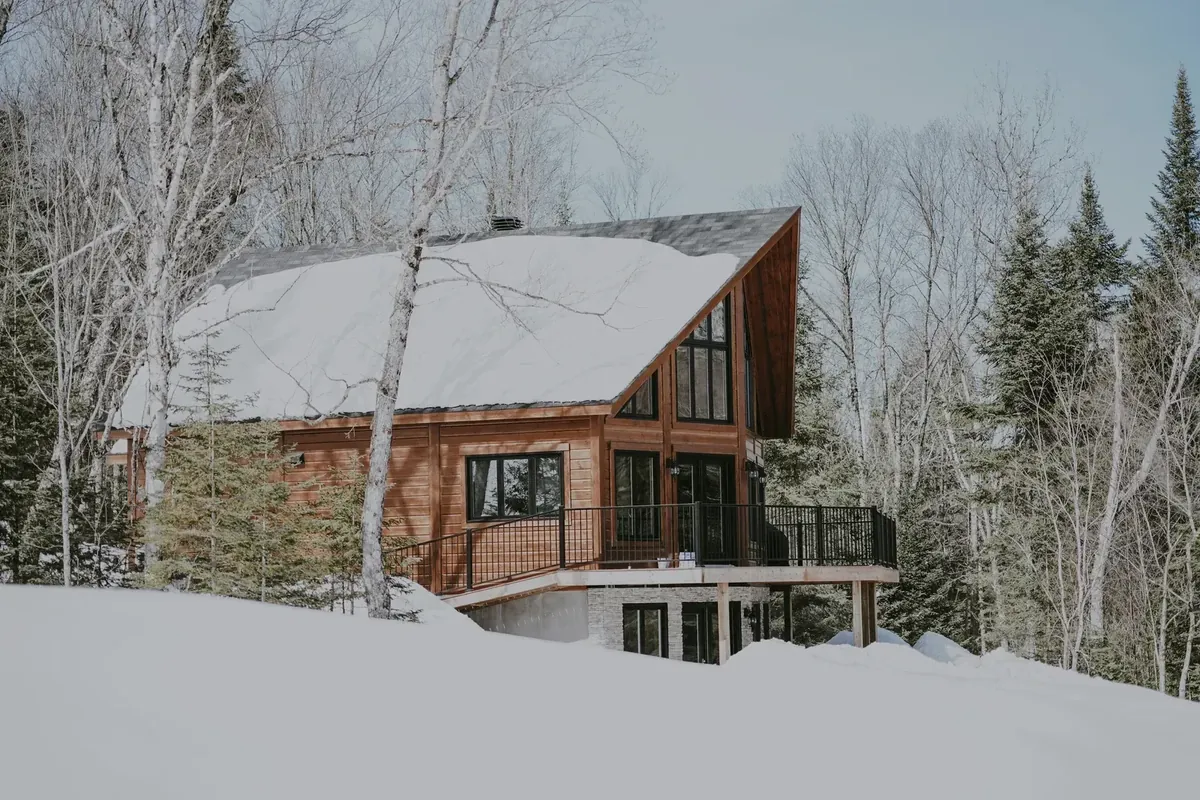 Chalet en rondins dans une forêt enneigée