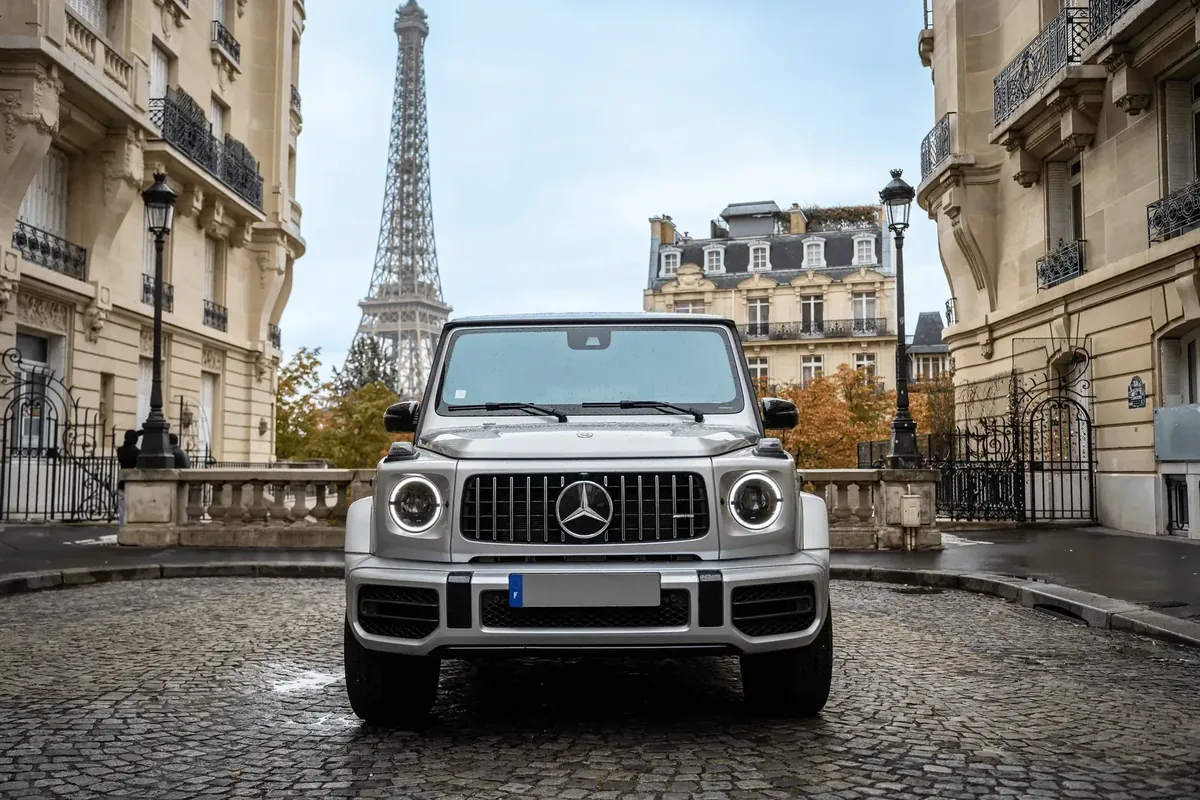 Mercedes-AMG G63 argent sur les pavés parisiens, tour Eiffel en arrière-plan
